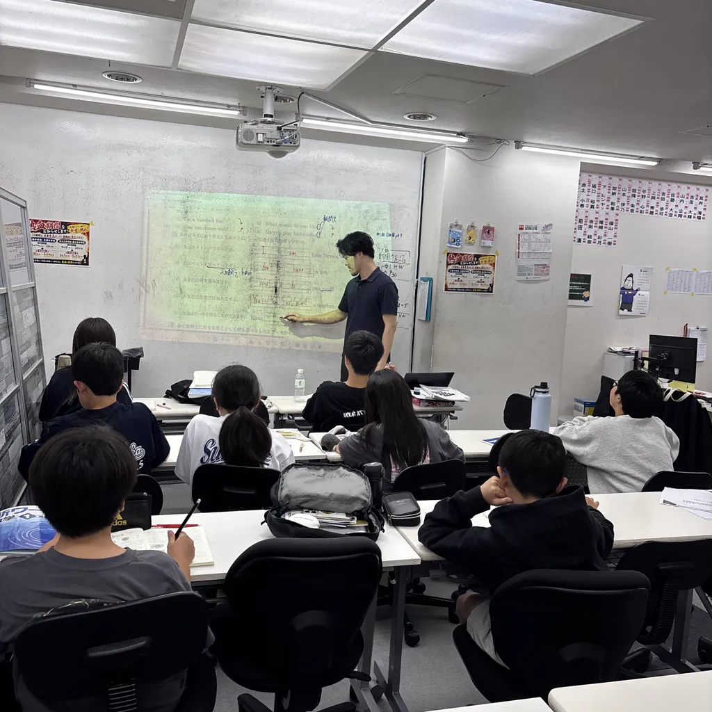創心館の教室で、講師がスクリーンに映した英語の問題を解説している様子