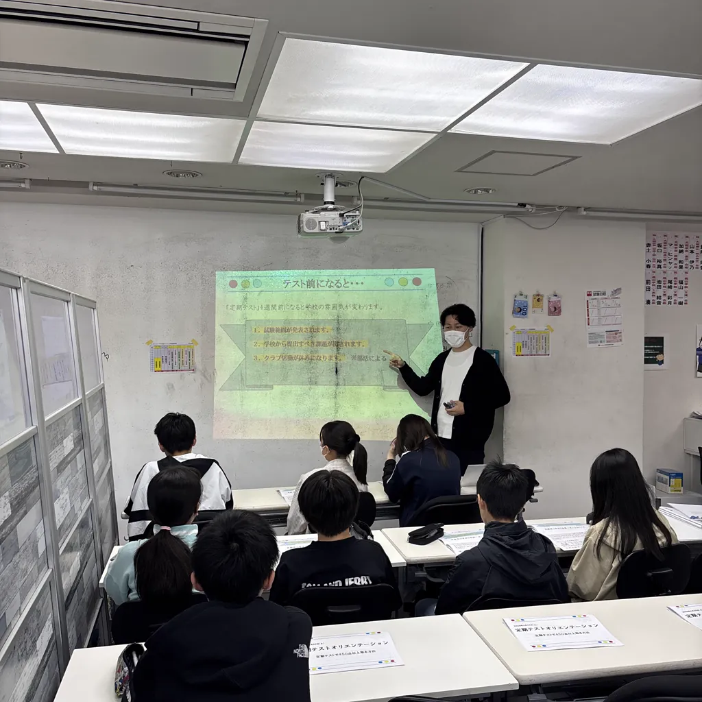 創心館の教室で、講師がスクリーンを使って説明している様子